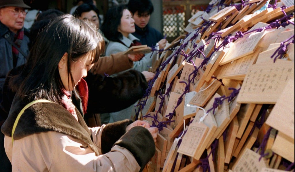 A young woman adds an ‘ema’ to a rack at a shrine in Tokyo. Photo: AP