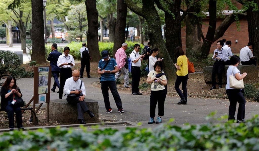 People play Pokémon Go at a park in Tokyo, Japan. Photo: Reuters