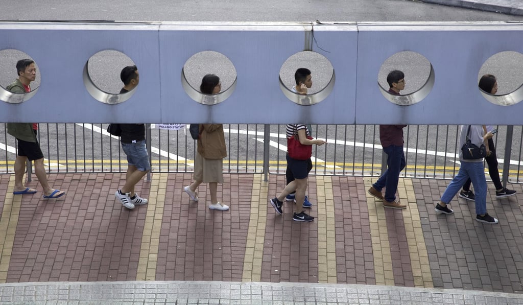 Hongkongers queue up to vote outside a polling station on Sunday. Photo: AP Hongkongers queue up to vote outside a polling station on Sunday. Photo: AP