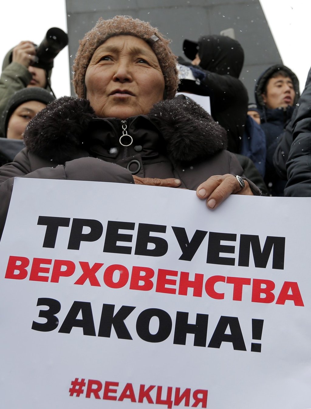 Protesters hold placards reading “We demand the rule of law”. Photo: EPA