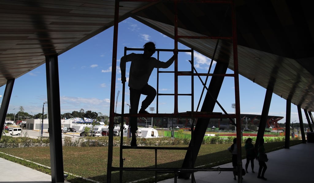 Labourers rush to finish work on the New Clark City Aquatics Centre on Thursday. Photo: EPA Labourers rush to finish work on the New Clark City Aquatics Centre on Thursday. Photo: EPA