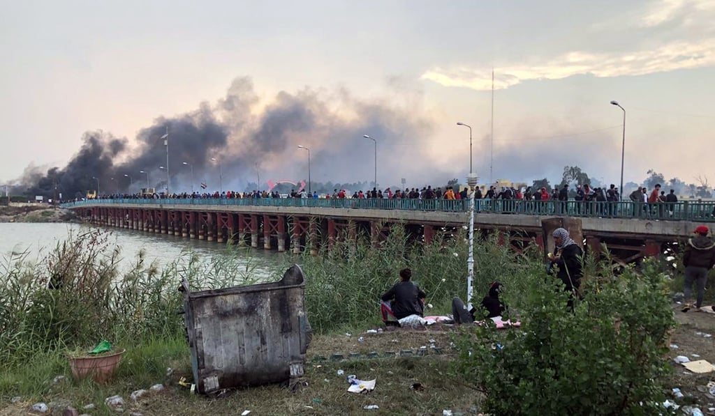 Smoke clouds rise from a military base which was reportedly stormed by Iraqi protesters during clashes with security forces in Nasiriyah. Photo: EPA