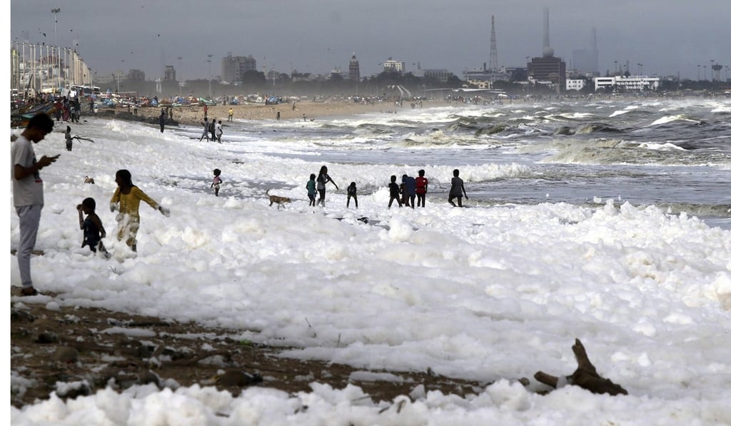 Children play on Marina beach in Chennai which is blanketed in foam. Photo: AP