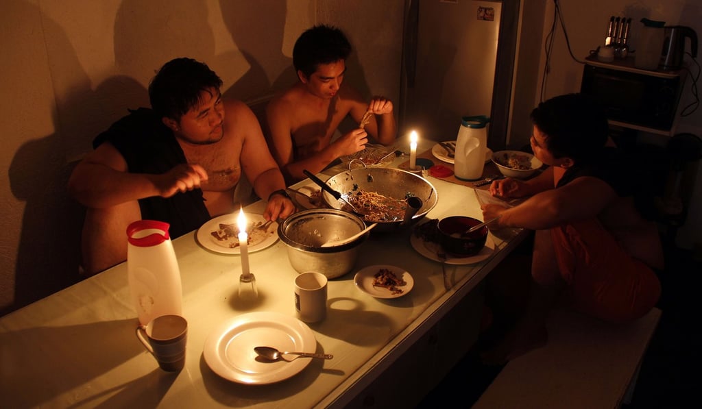 A Filipino family uses candles for light during a power cut in Legazpi City, Albay province, southeast of Manila. Photo: AFP