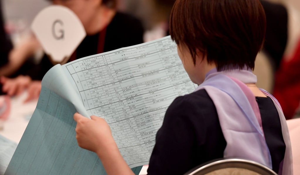 A woman checks a list of participants during a matchmaking party in Tokyo. Photo: AFP A woman checks a list of participants during a matchmaking party in Tokyo. Photo: AFP