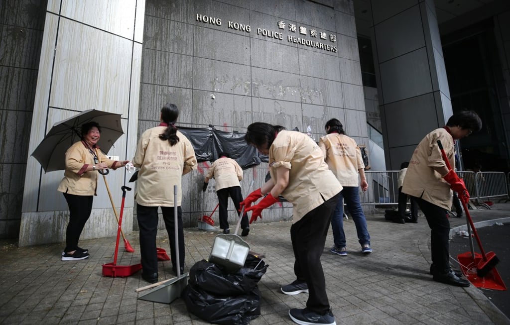 Workers clean up the mess left by protesters at a demonstration outside the Police Headquarters in Wan Chai. Photo: Winson Wong