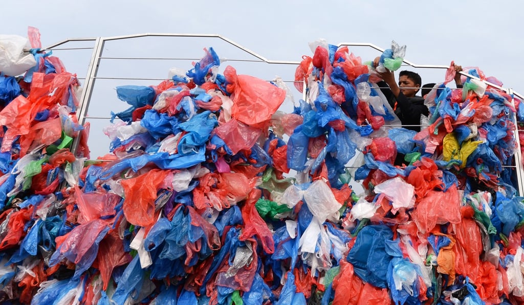 Nepalese volunteers and schoolchildren tie up recycled plastic bags to make a sculpture. Photo: AFP