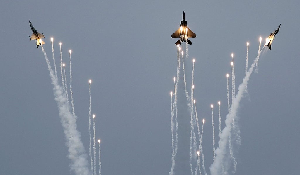 An F-15SG fighter jet (centre) and two F-16 fighter jets from the Republic of Singapore Air Force perform manoeuvres with pyrotechnics during an aerial display in 2018. Photo: AP