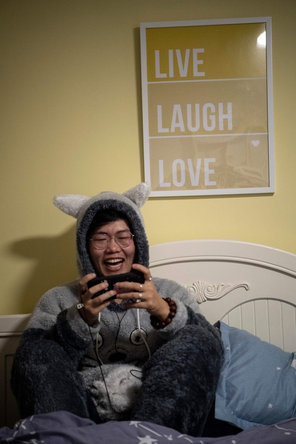 “Virtual boyfriend” Zhuansun Xu, 22, talks to a woman client while playing a mobile game in his room in Beijing. Photo: AFP