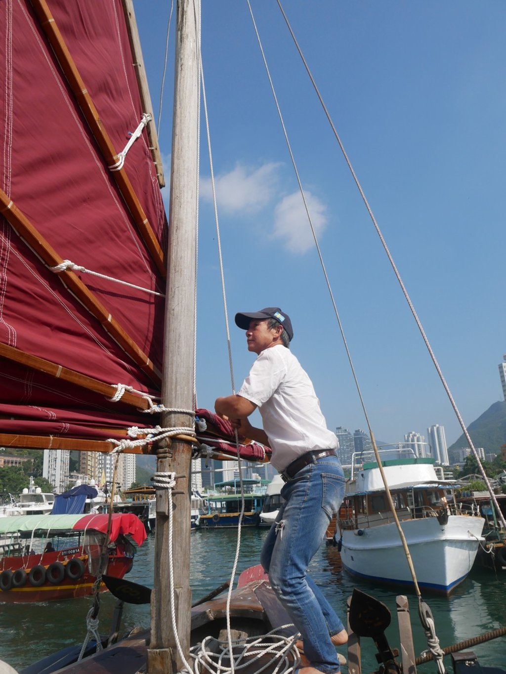Kwok hoists the sails of his junk, the Hong Kong Pioneer.