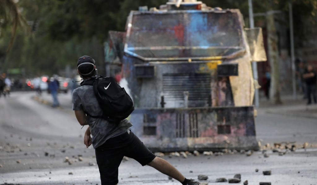 A demonstrator throws a rock at a riot police vehicle. Photo: Reuters