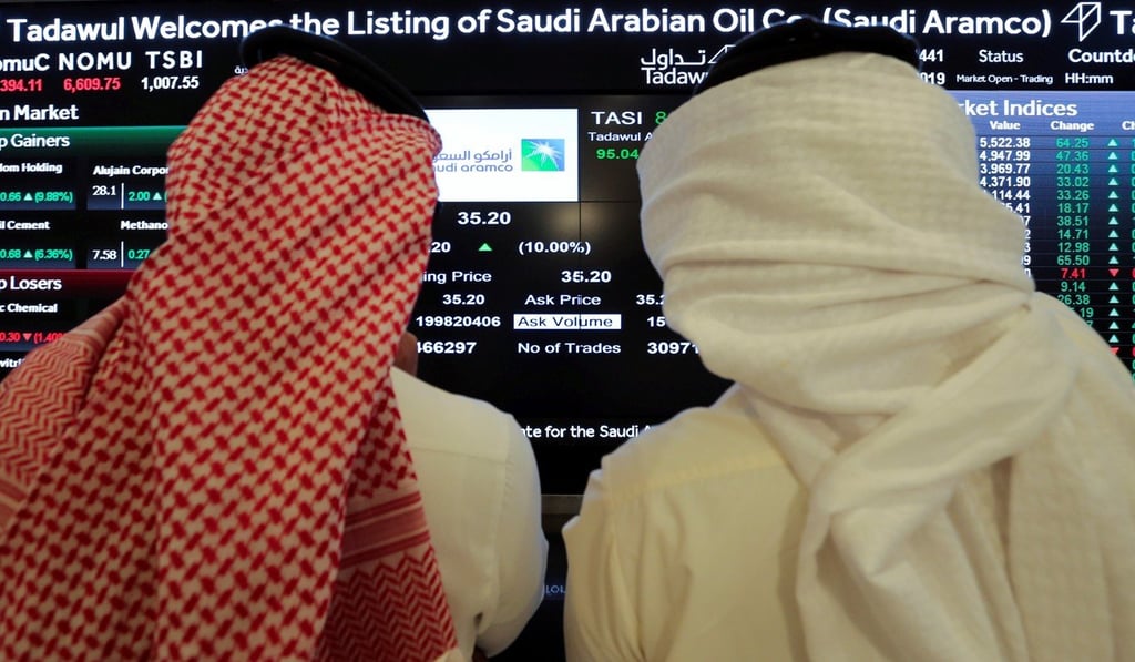 Investors monitor a screen displaying stock information at the Saudi stock exchange following the debut of Saudi Aramco’s IPO on Riyadh’s stock market on Wednesday. Photo: Reuters