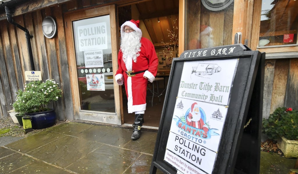 A man dressed as Santa Claus walks from his grotto at the Dunster Tithe Barn near Minehead, Somerset, England which is being used as a polling station on Thursday. Photo: PA via AP