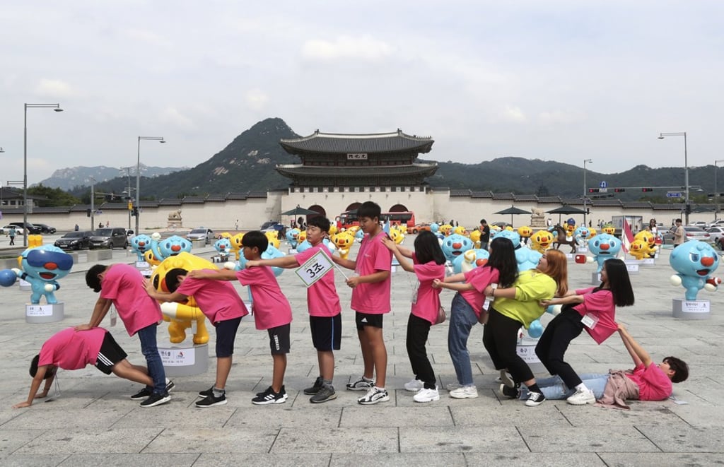 South Korean middle-school students pose with mascots of the National Sports Festival in front of Gyeongbok Palace in Seoul on August 27. Photo: AP