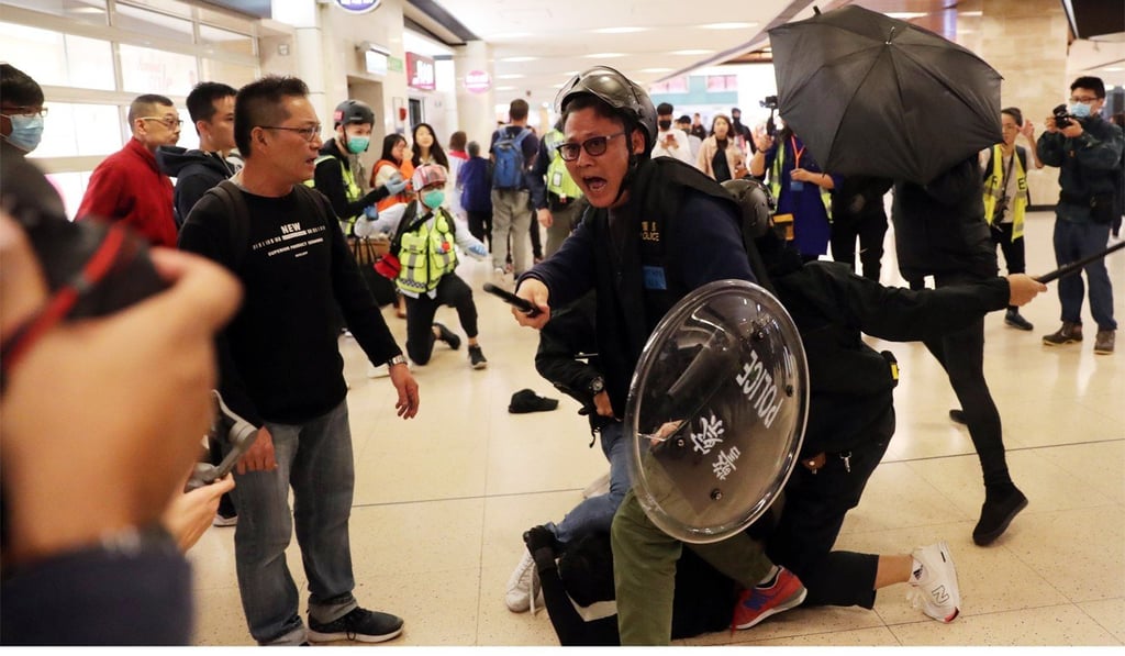 Police detain a man in New Town Plaza. Photo: Sam Tsang