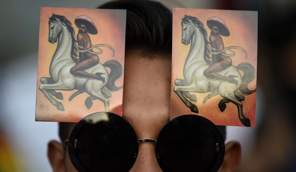 A member of the LBGT community takes part in a demonstration to support Mexican artist Fabian Chairez’ controversial painting titled “La Revolucion (2014)”, part of a commemorative exhibition called “Emiliano Zapata after Zapata”, outside the Museum of Fine Arts, in Mexico City on December 13. Photo: AFP