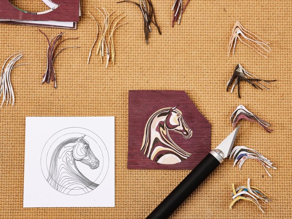The watch dial recreates Hermès’ favourite motif of a horse with a blend of different woods. The watch dial recreates Hermès’ favourite motif of a horse with a blend of different woods.