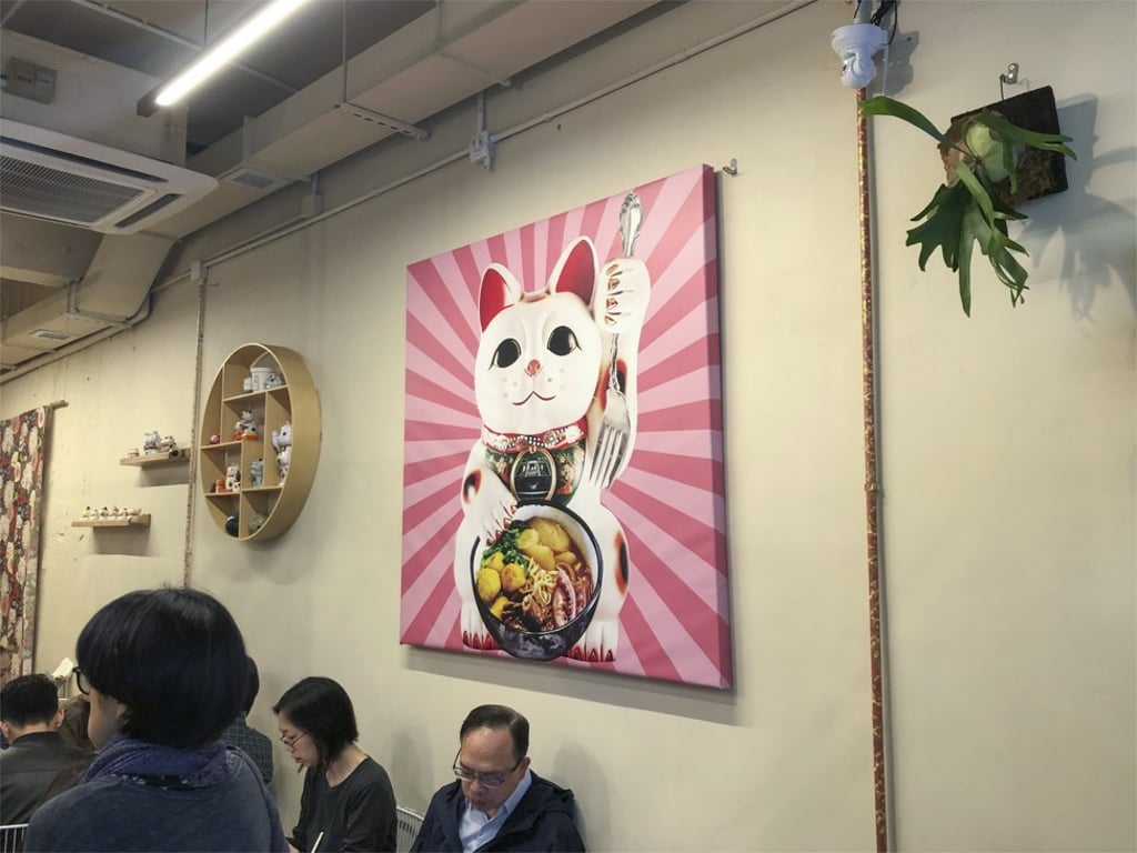 The interior of Red Pocket Cart Noodles Cafe decorated with a fortune cat print. Photo: Gigi Choy