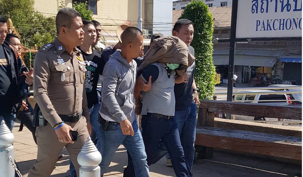 Serial killer Somkid Pumpuang (covered) is escorted by police shortly after being arrested at a railway station in northeastern Thailand. Photo: EPA-EFE Serial killer Somkid Pumpuang (covered) is escorted by police shortly after being arrested at a railway station in northeastern Thailand. Photo: EPA-EFE