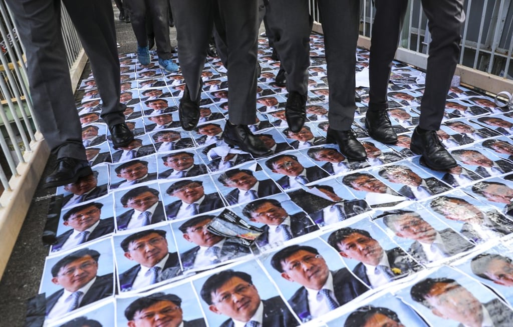 Anti-government posters showing the face of controversial politician Junius Ho placed across a footbridge in Wan Chai for people to walk on. Photo: Sam Tsang