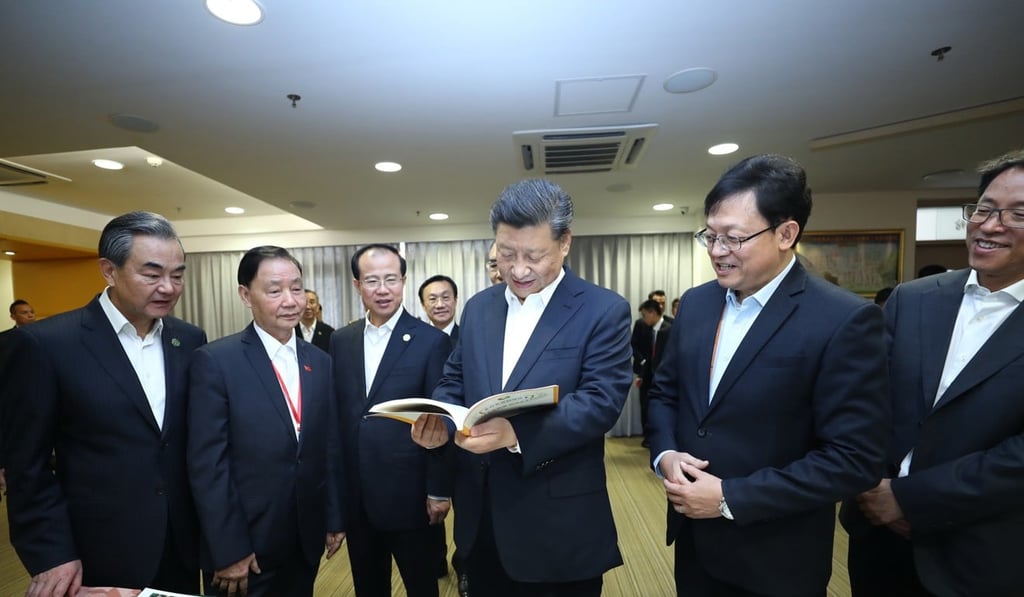 Chinese President Xi Jinping looks through textbooks on Chinese history, virtue and citizenship at the Premier School Affiliated to Hou Kong Middle School. Photo: Xinhua