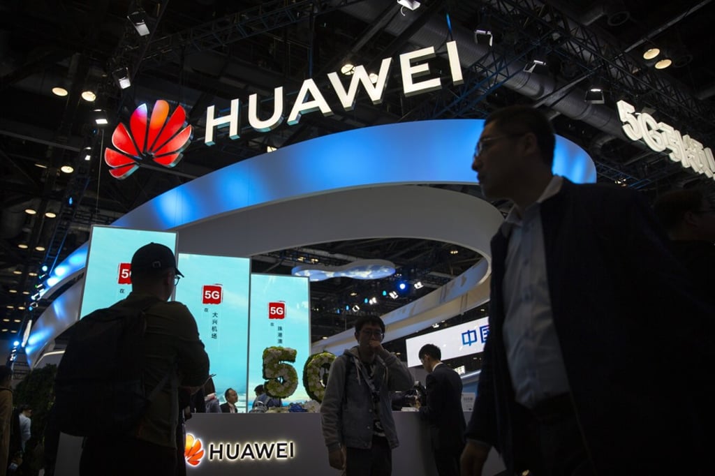 Attendees walk past a display for 5G services from Chinese technology firm Huawei at the PT Expo in Beijing. Photo: AP