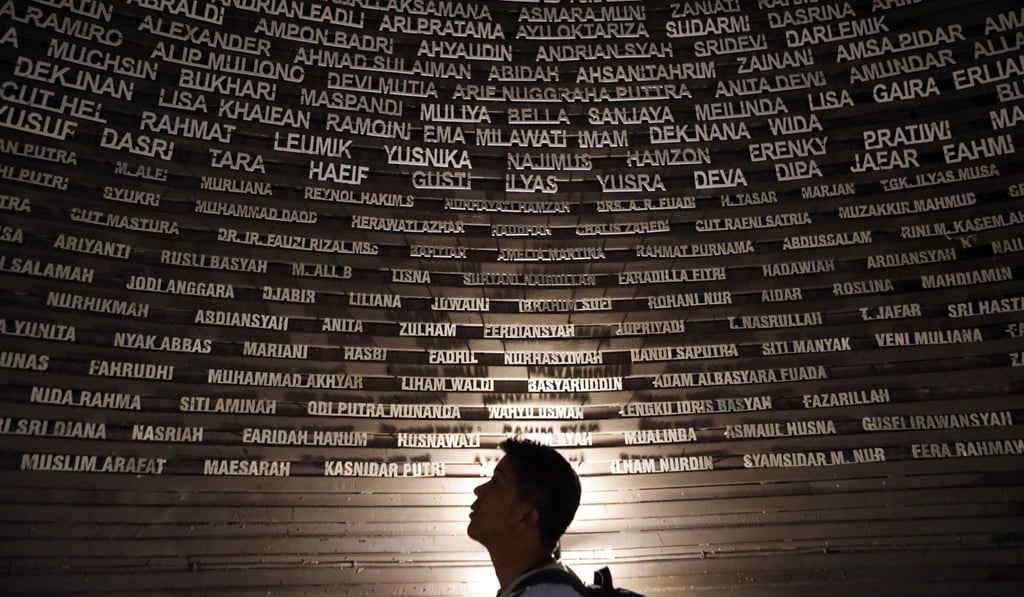 A visitor looks at a wall with the names of victims at the Tsunami Museum in Banda Aceh. Photo: EPA