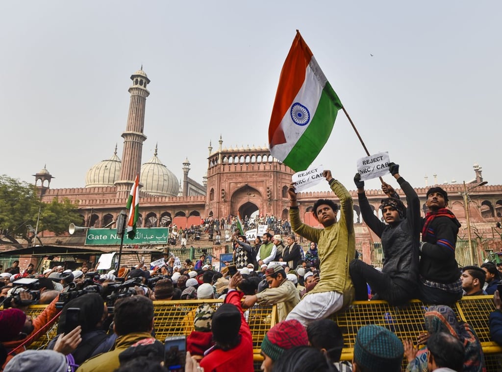 A protester holds the Indian flag during a demonstration at Jama Masjid against the new citizenship law. Photo: DPA