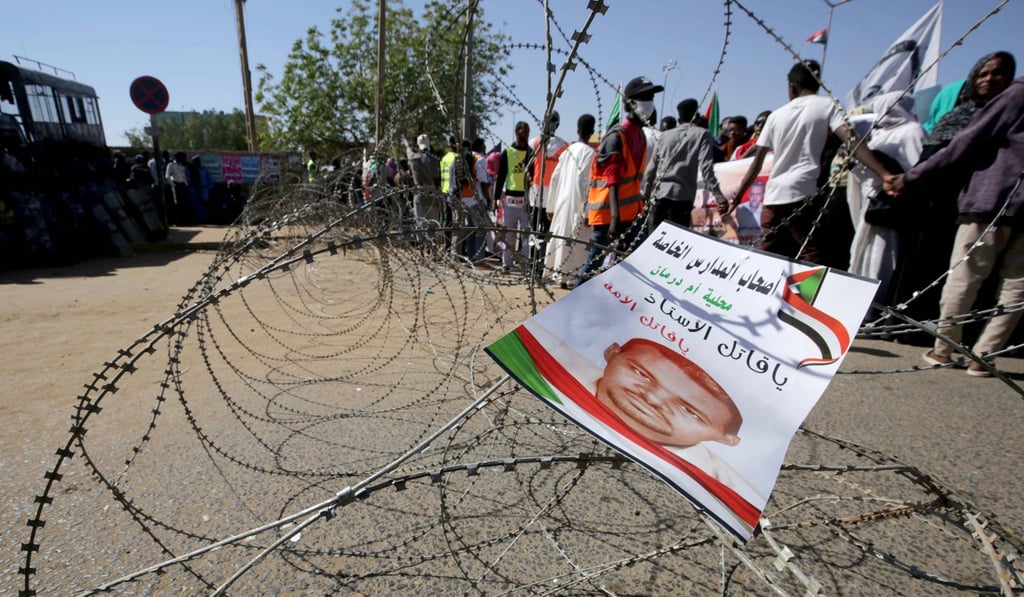 A flier bearing an image of Ahmed al-Kheir Awadh, a detained Sudanese demonstrator who died while in custody, hangs on barbed wire in Omdurman. Photo: EPA-EFE