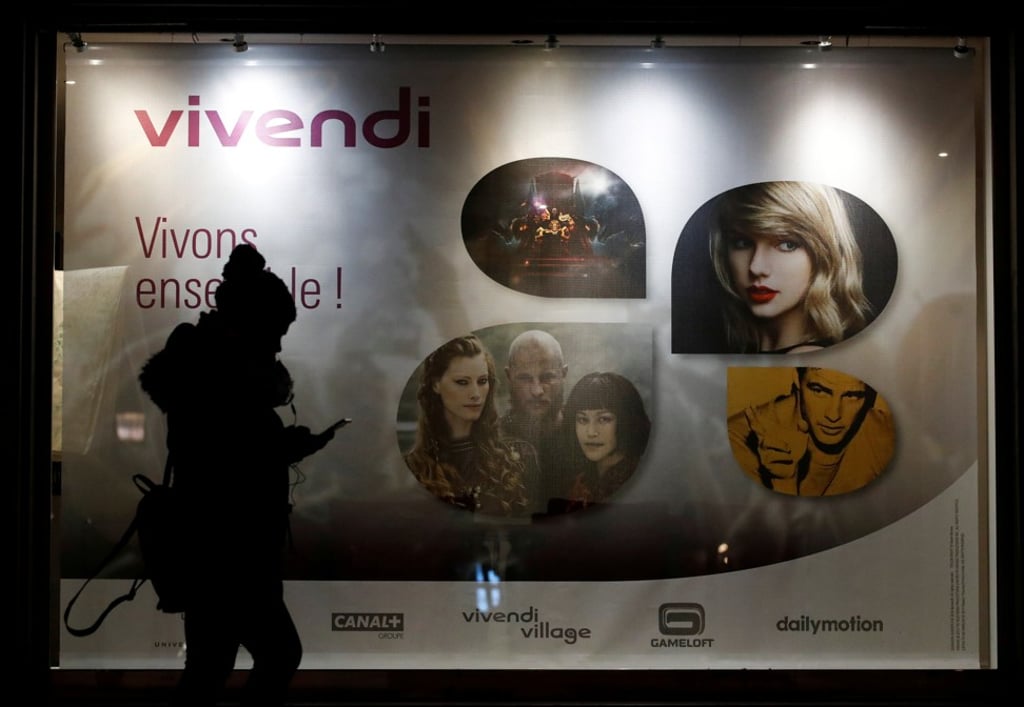 A woman walks pass by a sign of Vivendi at the main entrance of the entertainment-to-telecommunications conglomerate’s headquarters in Paris on November 21. Photo: Reuters