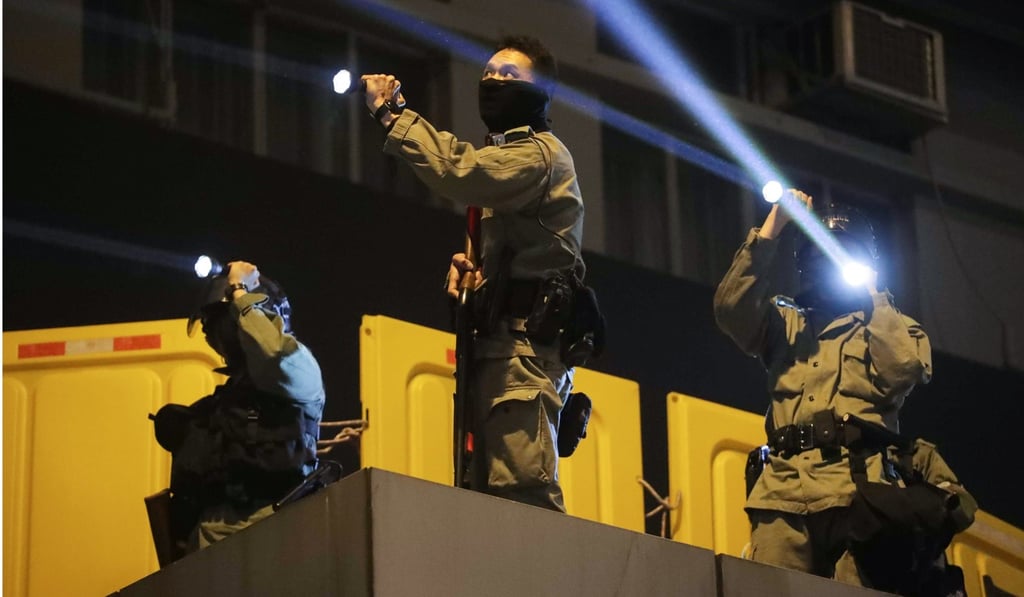 Officers point flashlights at anti-government protesters at Mong Kok Police Station on December 31. Photo: Edmond So