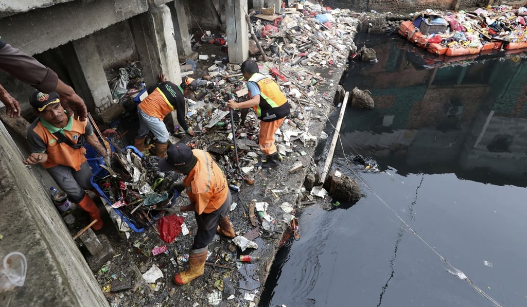 Municipal workers clean up after floods in Jakarta, Indonesia. Photo: AP