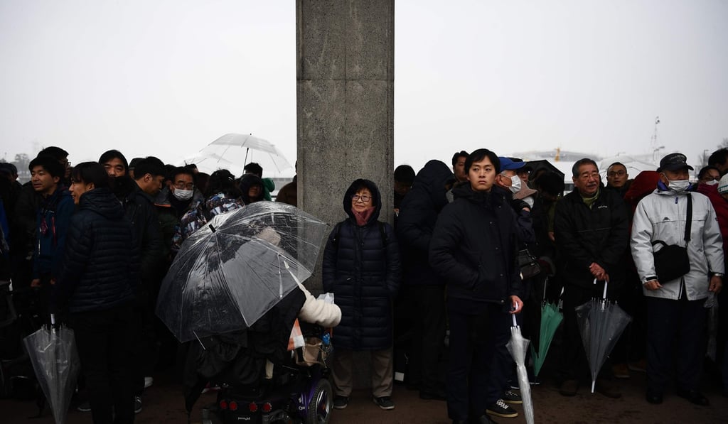 People stand in the rain outside a court in Yokohama to attend the trial of Satoshi Uematsu. Photo: AFP