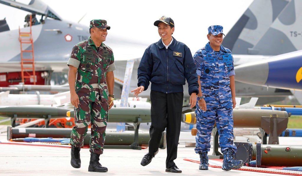 Indonesian President Joko Widodo walks past fighter jets and weapons during a military exercise on Natuna Island. Photo: AFP