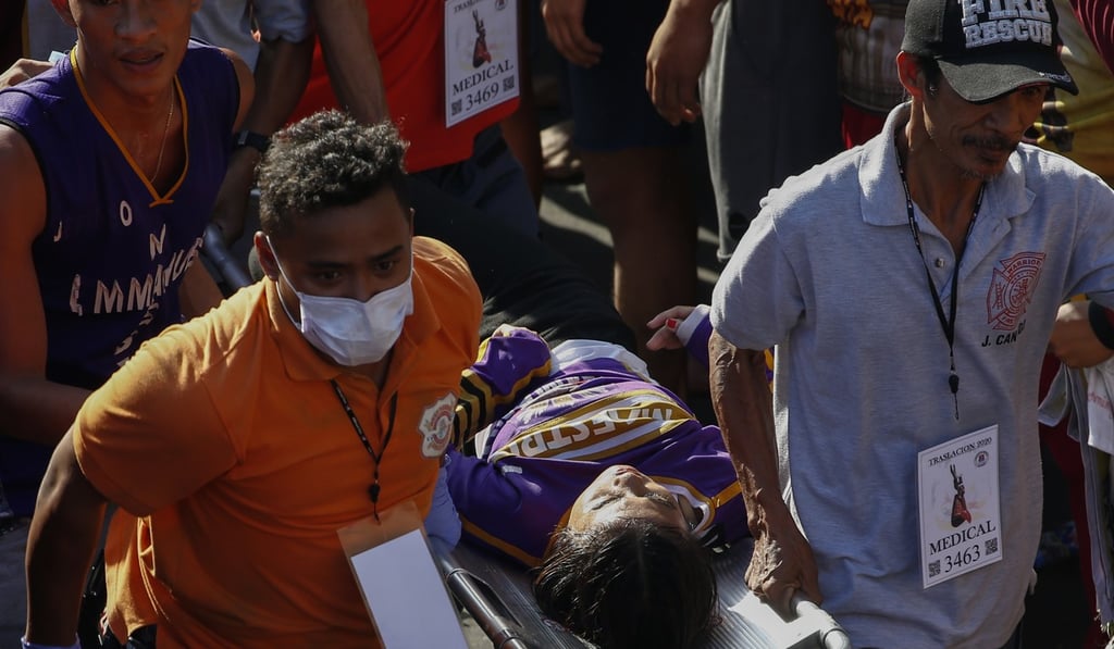 Emergency responders carry a Catholic devotee at the procession. Photo: EPA