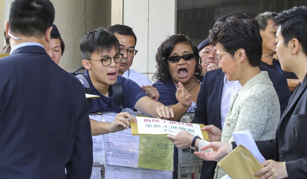 A member of the Justice and Peace Commission of the Hong Kong Catholic Diocese hands a letter about housing policy to Hong Kong Chief Executive Carrie Lam as she arrives for an Executive Council meeting at the government headquarters on October 15, 2019. Since the protests began, Lam’s attendance at meetings with her cabinet is one of the only opportunities for members of the public to see her in person. Photo: May Tse