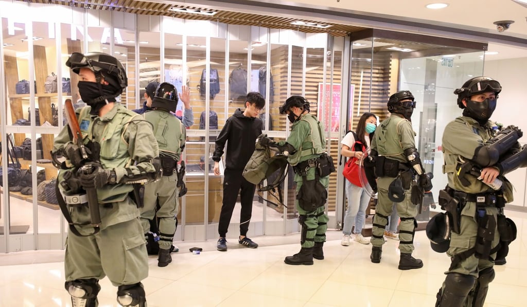 Riot police officers search people at MOKO shopping mall in Mong Kok, as protesters stage a “Christmas shopping” rally on December 16. Photo: Nora Tam