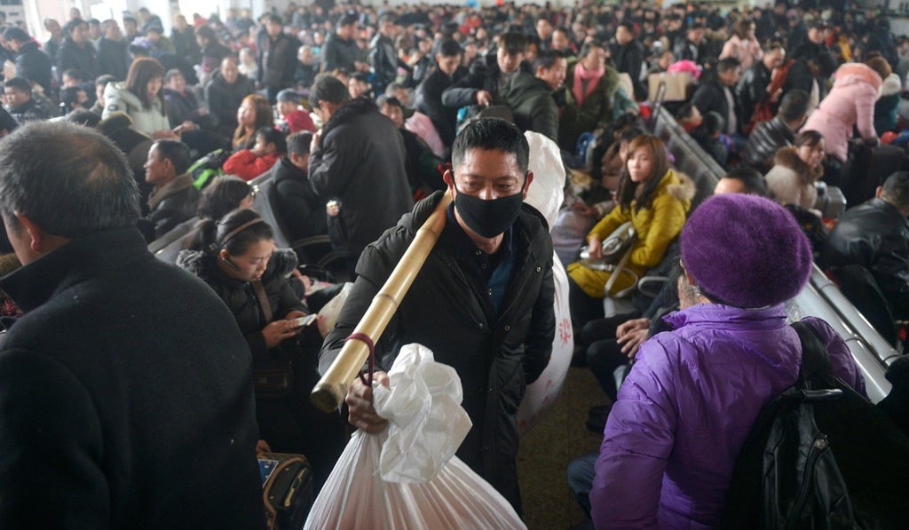 A man carries his belongings as he walks among passengers on the first day of the annual Spring Festival travel rush in 2019. Photo: Reuters