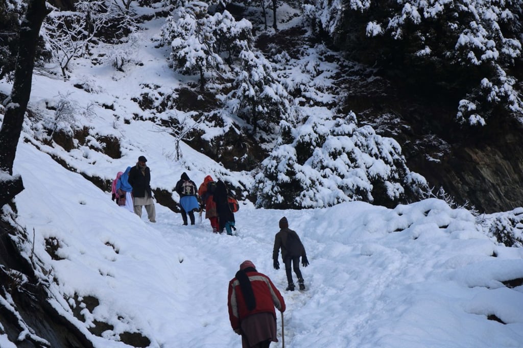 People walk on a snow-covered mountain path in Neelum valley, Pakistani-administered Kashmir, January 14, 2020. Photo: EPA-EFE