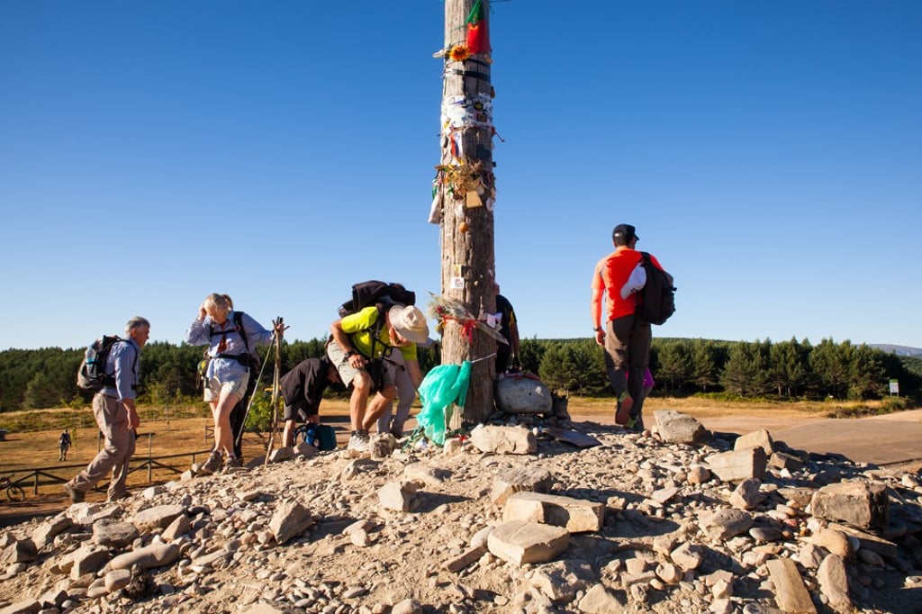 Pilgrims climb up to the Cruz de Hierro (“iron cross”) on the Camino de Santiago, in Spain. Photo: Shutterstock