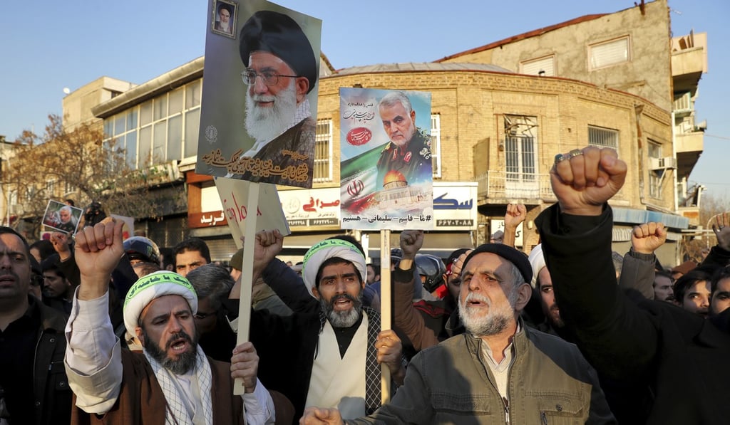Protesters hold posters of slain General Qassem Soleimani and Supreme Leader Ayatollah Ali Khamenei in Tehran on Sunday. Photo: AP
