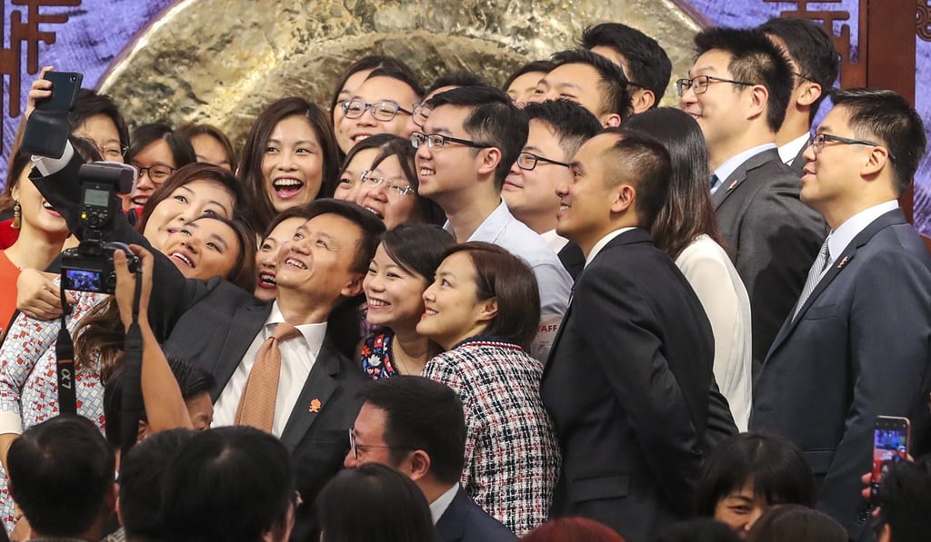 Staff take selfies with Daniel Zhang Yong, the chief executive officer and chairman of Alibaba, during its IPO at Exchange Square in Central. Photo: Sam Tsang