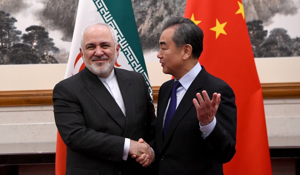 Iran’s Foreign Minister Mohammad Javad Zarif (left) and his Chinese counterpart Wang Yi shake hands during a meeting at the Diaoyutai State Guesthouse in Beijing on December 31. China promised Iran substantial investments last year. Photo: EPA-EFE