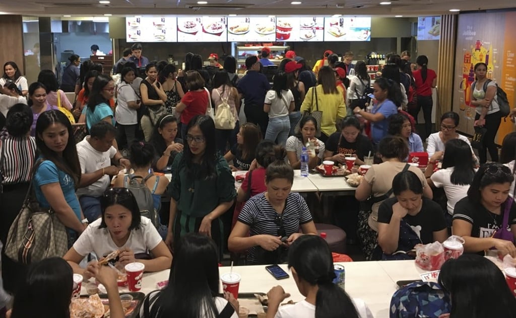 Filipino domestic helpers gather at a Jollibee outlet in Hong Kong. New online platform Pangyao will promote relevant social events and services for migrant workers. Photo: Cheryl Arcibal