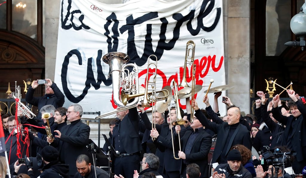 Musicians of the Paris Opera's orchestra react after playing an improvised open-air concert outside the Opera Garnier to protest the government's proposed pension reform. Photo: Reuters Musicians of the Paris Opera's orchestra react after playing an improvised open-air concert outside the Opera Garnier to protest the government's proposed pension reform. Photo: Reuters