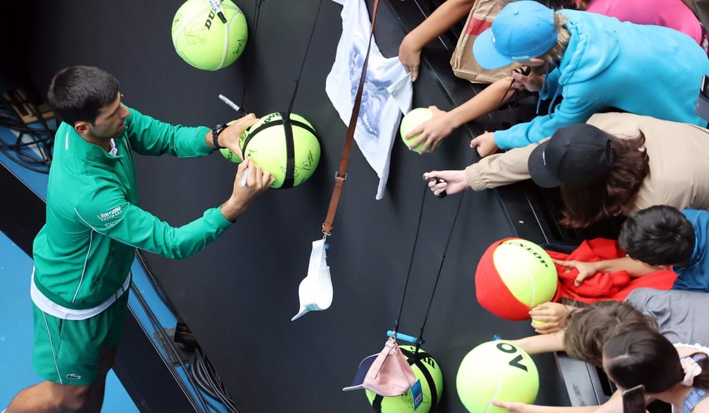 Djokovic signs autographs for spectators after his win against Japan's Tatsuma Ito in Melbourne. Photo: AFP