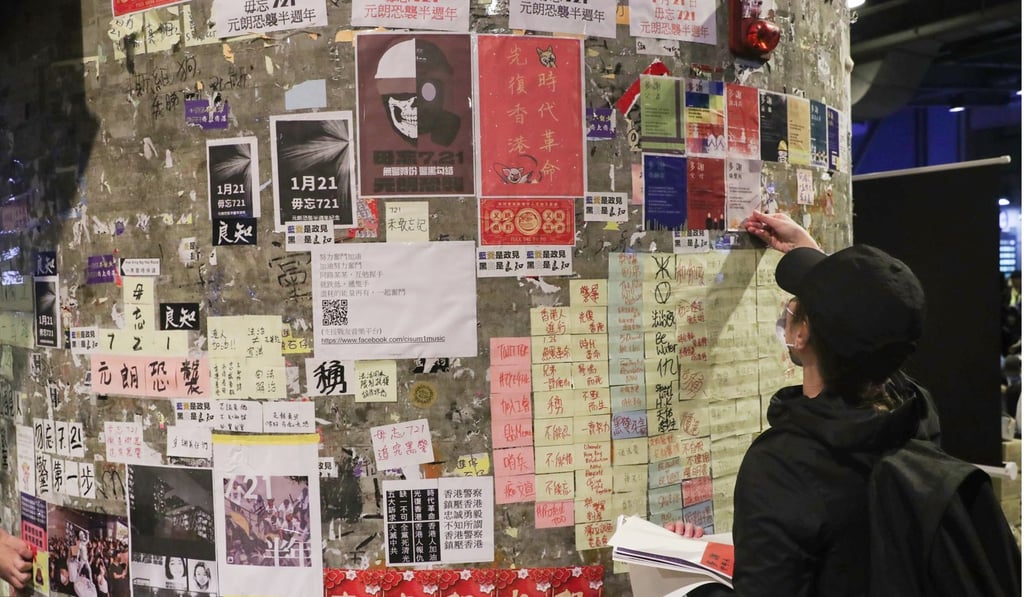A protester in Yuen Long sticks a message on a wall. Photo: Sam Tsang A protester in Yuen Long sticks a message on a wall. Photo: Sam Tsang