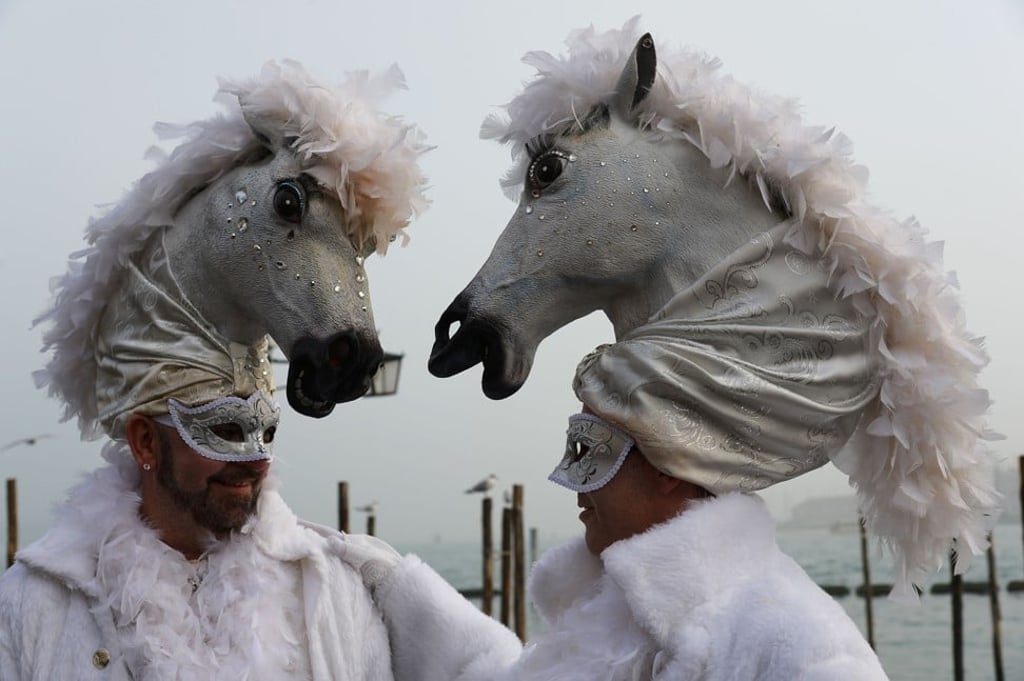 Costumed revellers pose in St Mark’s Square during the 2016 Venice Carnival. Photo: AFP