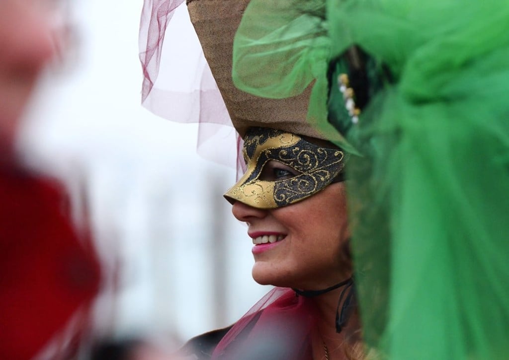 A costumed reveller smiles at St Mark’s Square during the 2016 Venice Carnival. Photo: AFP
