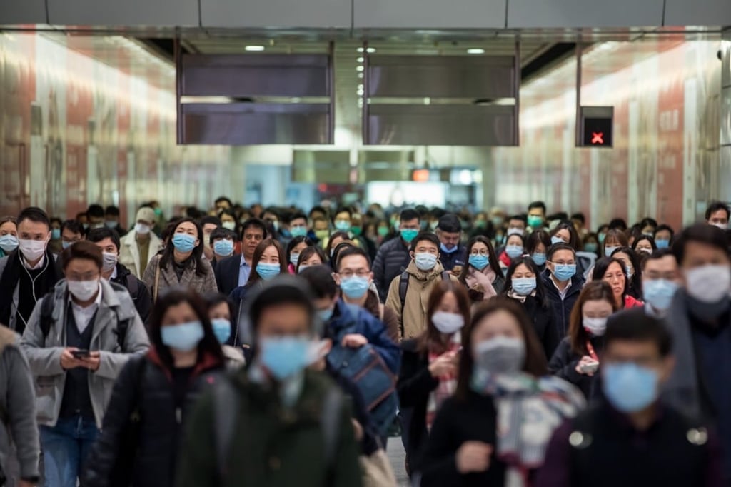 Commuters wearing protective masks walk through Hong Kong station. Photo: Bloomberg